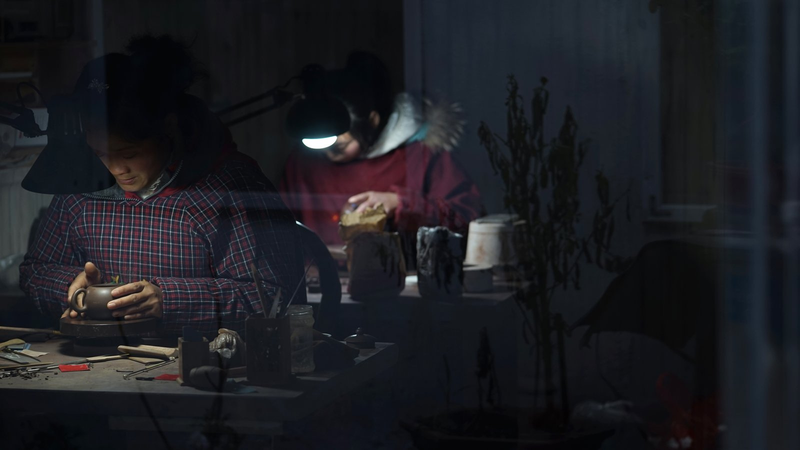 A Yixing potter fitting a spout and handle on a teapot body in her Gunan Street workshop