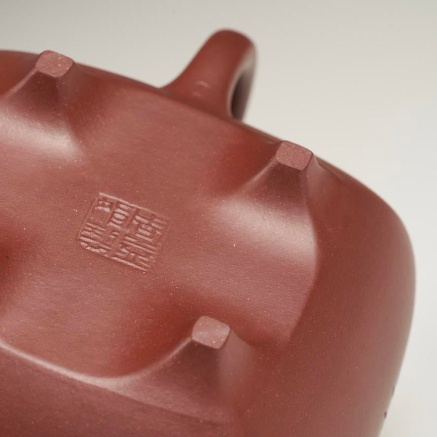 The underside of a Yixing teapot, showing the maker’s stamp (seal) and the feet