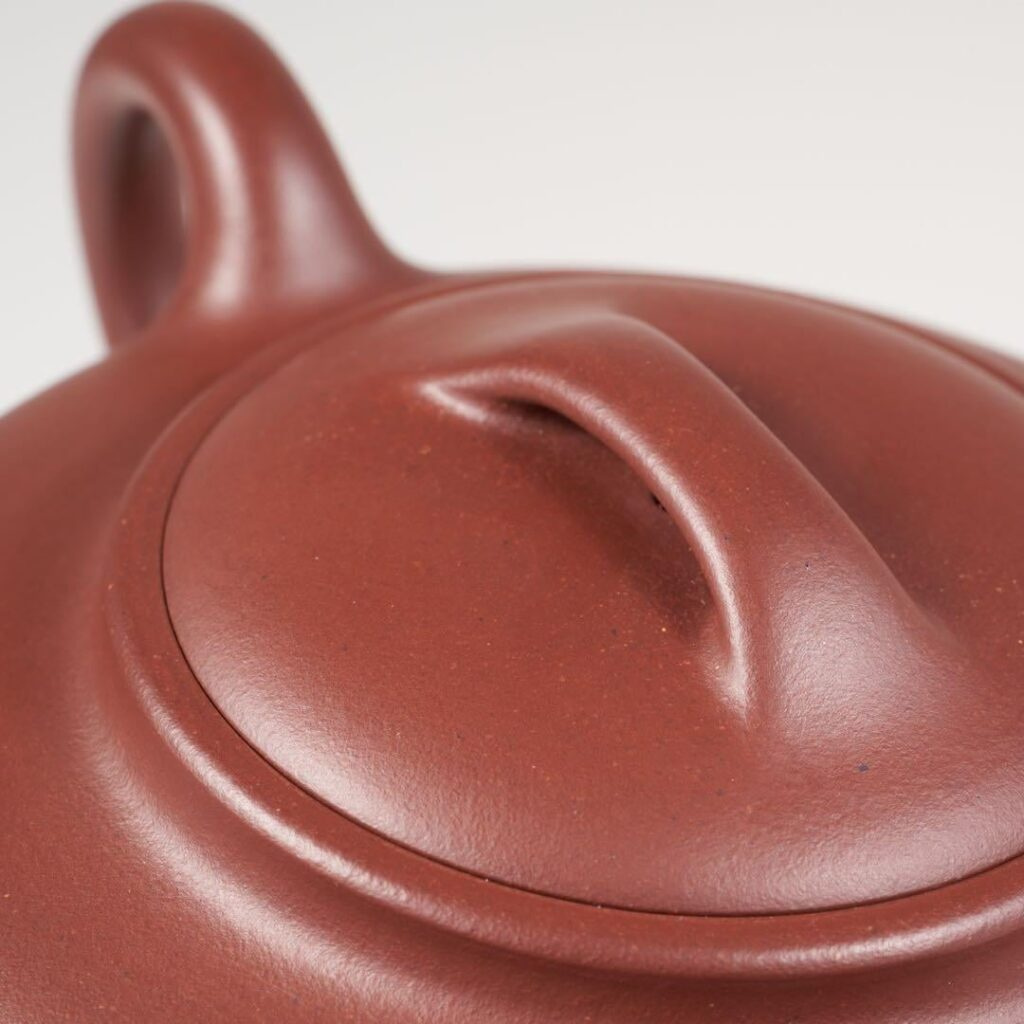 A Yixing teapot lid and bridge knob with consistent burnished texture, an example of excellent Mingzhen work